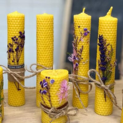 Bougies en cire d’abeille jaune décorées de fleurs séchées et de ficelle en lin naturel