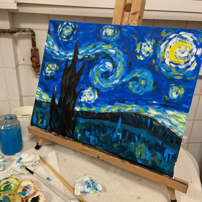 Toile peinte à l’acrylique représentant une version de La Nuit étoilée de Van Gogh, posée sur un chevalet